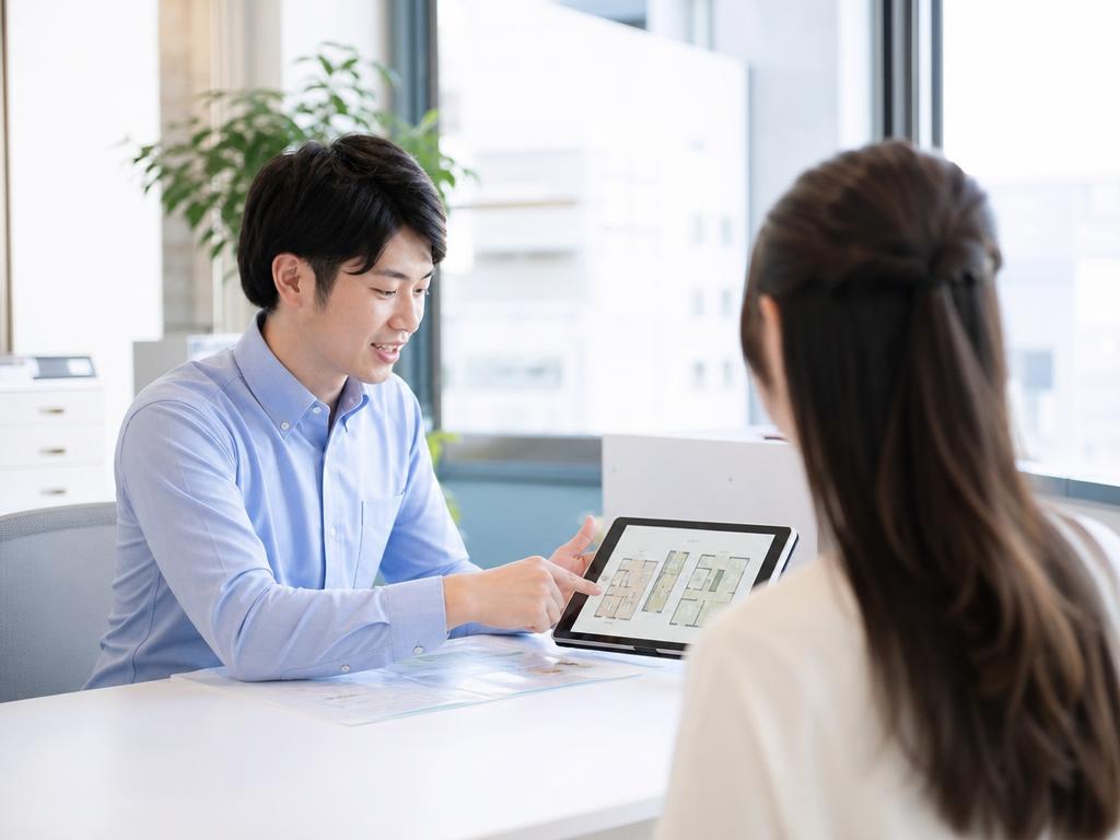タブレットで物件を案内するスタッフ